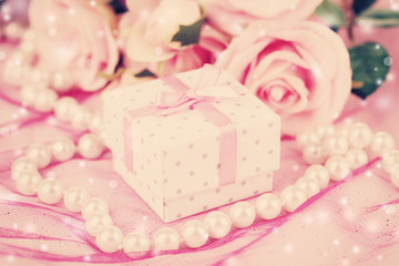 Fototapeta na wymiar Flowers and gift box on pink background