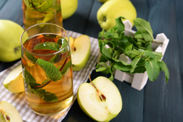 Glasses of apple juice with fruits and fresh mint on table close up