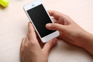 Woman using mobile phone on workplace close up