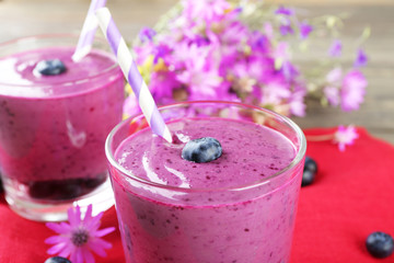 Glasses of blueberry smoothie on red napkin, closeup