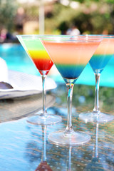Cocktails on swimming pool background
