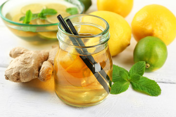 Iced tea with lemon on light wooden background