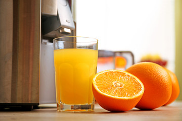 Juicer and orange juice on kitchen table