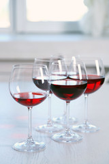 Glasses of red wine on table on bright background