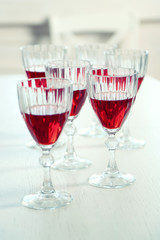 Glasses of red wine on table on bright background