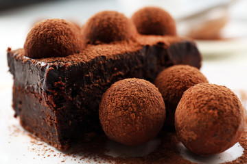 Slice of chocolate cake with a truffle on plate closeup
