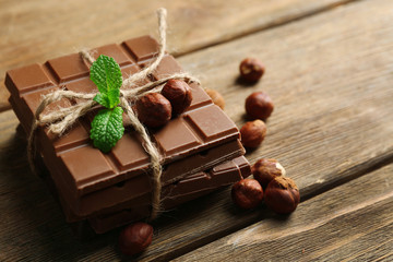 Black chocolate pieces with nuts on wooden background