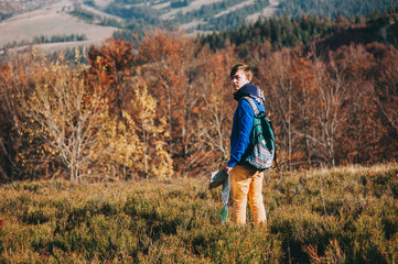 Naklejka na ściany i meble fellow tourist with map in hand and phone. autumn mountains