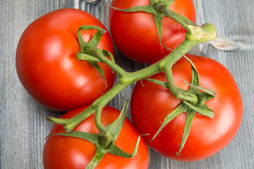 branch with ripe tomatoes on a wooden surface