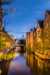 Beautiful view of Lieve river with bridge and houses of bricks color in Ghent, Flemish region of Belgium
