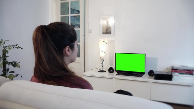 Green Screen Television Girl - Full HD. Girl watches television with green screen / shot behind model's shoulders

