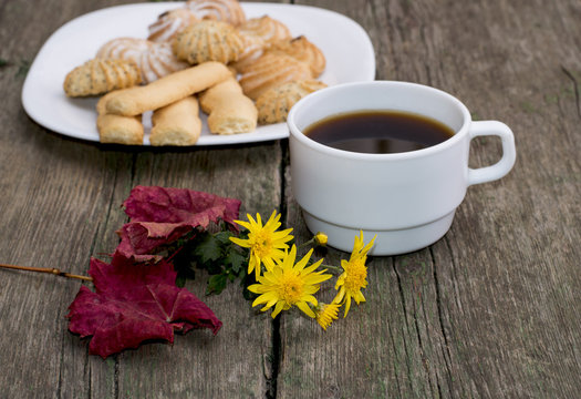 coffee, leaf, floret and plate with cookies behind, a still life