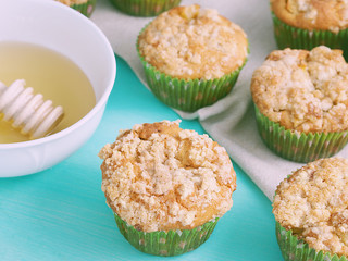 Apple crumb spiced muffins on on green pastel wooden table with beige table napkin