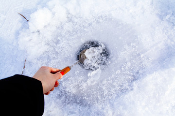 clean ice hole in frozen lake for winter fishing