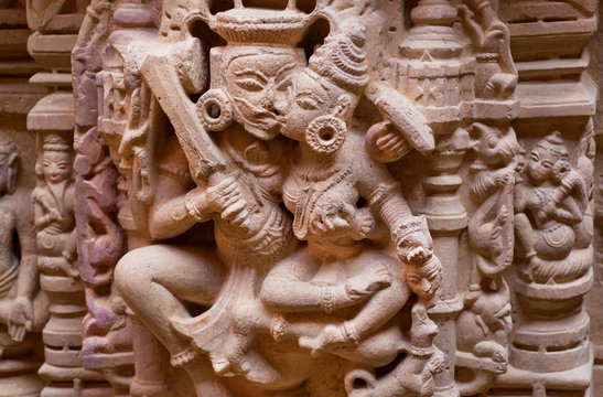 Kiss of the Gods on carved wall of sandstone bas-relief in 12th century Jain temples, India.