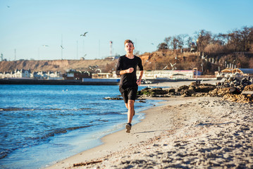 Running man. Male runner jogging during the sunrise on beach