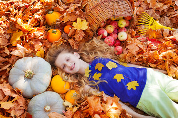 Portrait of beautiful girl on leaves with pumpkins
