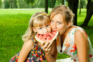 mother and daughter eating watermelon