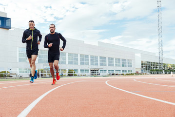Group of young people running on the track field