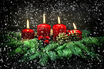 Advent decoration. Four red burning candles with falling snow