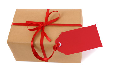 Brown paper package parcel or present one single small tied with red ribbon and gift tag for christmas birthday or valentine isolated on white background photo