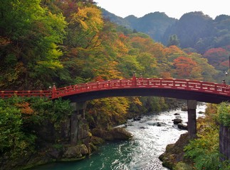 Fototapeta premium Shinkyo Bridge during Autumn in Nikko, Tochigi, Japan. This beautiful vermilion lacquered structure is known as one of the three most beautiful bridges in Japan and is a perfect gateway for Nikko.