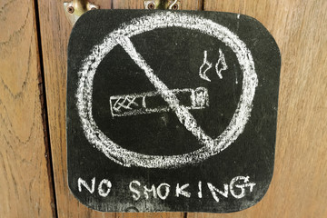 
Warning "no smoking'' written by a chalk on a blackboard
