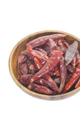 Dried chili pepper in wooden bowl on white background