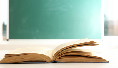 Women hands with book on blackboard background