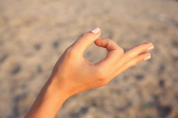 Woman hand on sand background