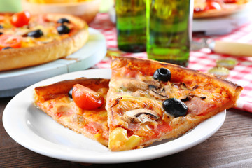 Sliced pizza served with beer on wooden table
