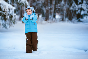 Fototapeta na wymiar Cute little boy playing on winter forest