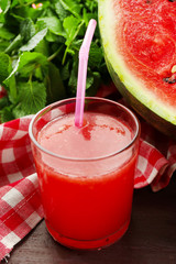 Cold watermelon drinks in glasses, on wooden table background