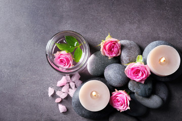 Obraz na płótnie Canvas Spa composition of candles, stones and flowers, on grey background