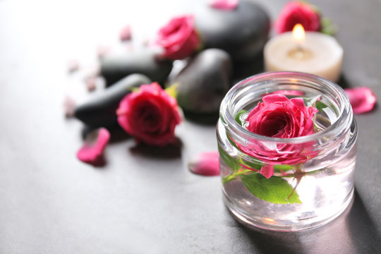 Fototapeta Spa composition of candles,  stones and flowers, on grey background