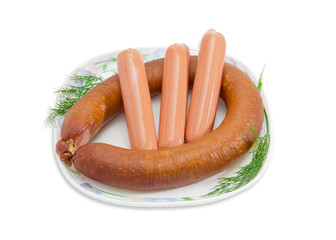 Sausages with branches of dill on a white dish