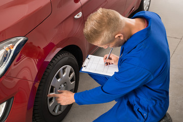 Mechanic Examining Car Wheel