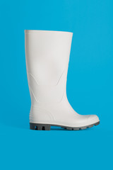 new white rubber boot isolated on blue background