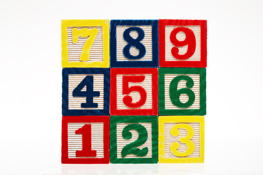 Colorful stacked toy plastic building blocks with numbers isolat