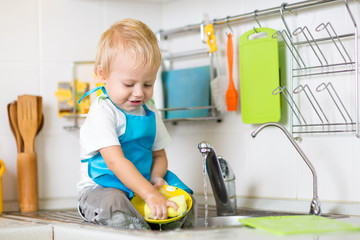 Child washing up in a domestic kitchen