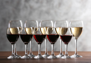 Half full wine glasses on table on light background