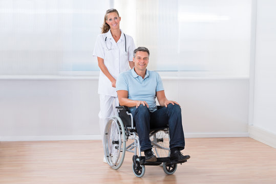 Doctor Carrying Patient On Wheelchair