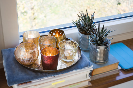 Books, candles and succulent plants on a windowsill. Selective focus.