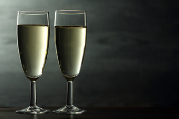 champagne glasses on wooden table on grey background
