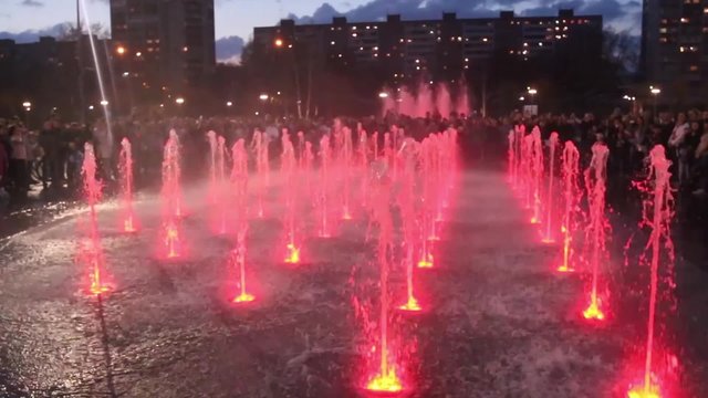 Beautiful fountain with colored illumination at evening in city
