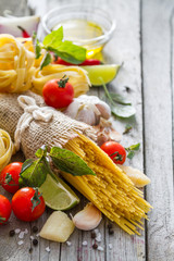 Pasta and ingredients on rustic background