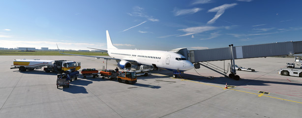 Passagierflugzeug am Flugsteig eines Flughafens  - Beladung mit Gepäck und tanken von Kerosin //...