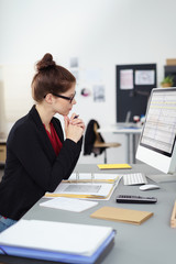 konzentrierte mitarbeiterin im büro schaut auf computer