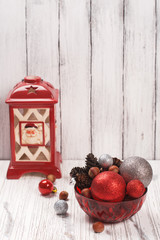Xmas or new year card with lantern, cones, nuts and balls. Space for text. Selective focus
