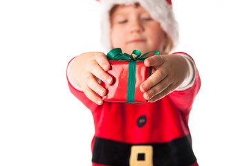 funny child in Santa red hat holding Christmas gift in hand. Chr